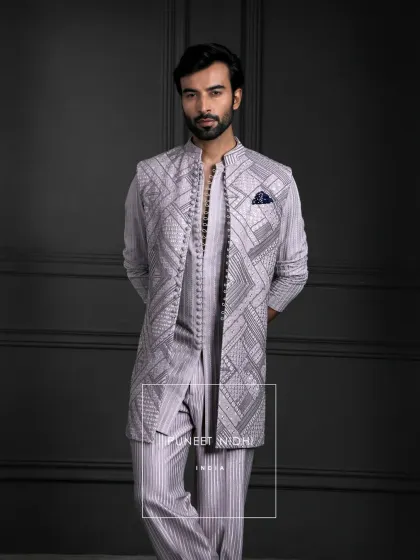 Subtle yet royal. A blush pink kurta with linear detailing and full front loop buttons, paired with an embroidered jacket for a touch of Indian elegance.