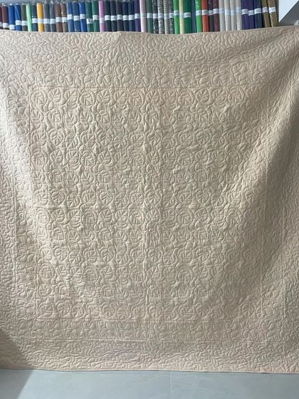 The back of the quilt, showing a dense, swirling quilting pattern.