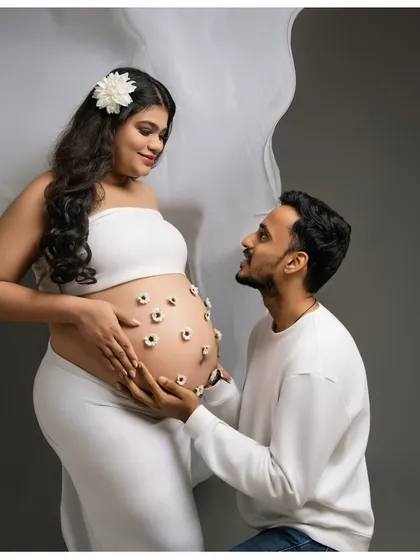 A family in bloom. The partner looks on with adoration as he holds the flower-adorned bump, a beautiful portrait of shared love and excitement for their growing family.