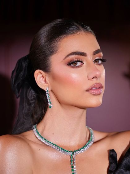 A close-up portrait showcasing the flawless skin and defined eyes of this coquette-inspired makeup.