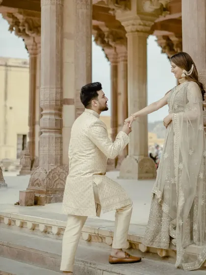 A beautiful proposal-style pose within the grand colonnade of a palace. The repeating pillars create a powerful visual that draws all the attention to the couple's special moment.