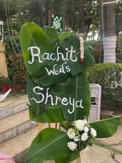 A personalized welcome sign written on banana leaves. This creative and eco-friendly detail is perfect for a South Indian or tropical-themed wedding, adding a unique and personal touch.