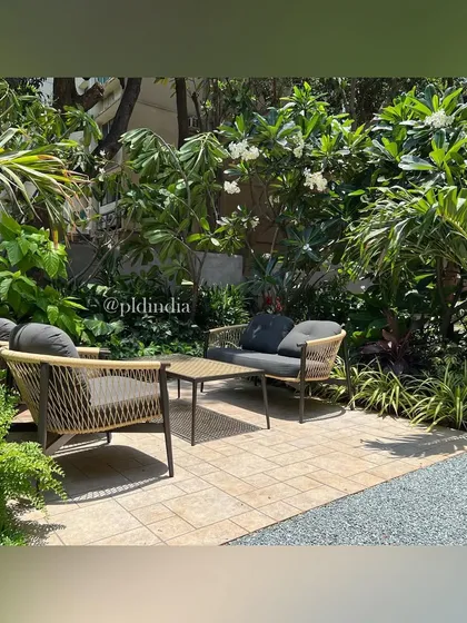 We created this cozy seating nook in an entrance garden in South Mumbai. Surrounded by frangipani trees and lush foliage, it offers a quiet place to sit and enjoy a moment of peace before entering or leaving the home.
