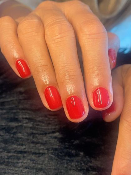 Mani magic! A classic, vibrant red gel polish on short, natural nails.