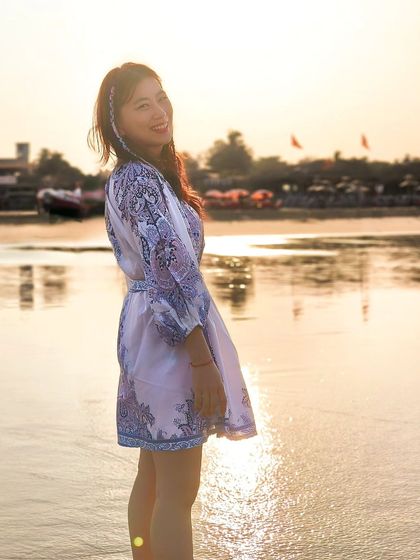 A beautiful portrait of a woman on the beach during golden hour, with the setting sun creating a warm, magical glow.