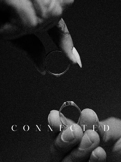 A powerful and symbolic black and white shot of the engagement rings, held apart but "Connected." This image represents the union of two souls.