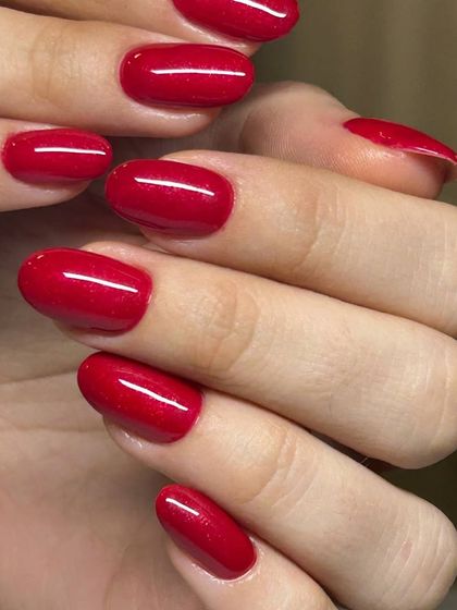 A classic shimmery red manicure. The fine glitter particles catch the light beautifully, adding a festive touch to a timeless color.