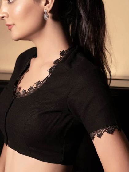 A side profile of the black lace-detailed blouse. You can see how the delicate lace trim adds a touch of elegance to the sleeves and neckline, making it a sophisticated choice.