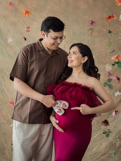 Pointing to the greatest adventure. This couple's portrait with tiny baby shoes is a sweet and simple way to announce their joy.
