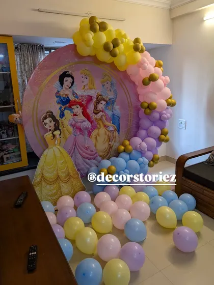 A magical Disney Princess theme, perfect for a royal celebration. This setup features a large circular backdrop with multiple princesses, a life-sized Belle cutout, and a pastel balloon garland.