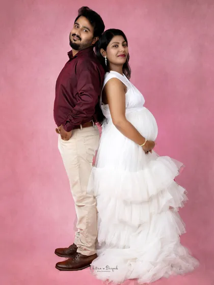 A fun back-to-back pose against a vibrant pink background. This shot is full of personality and style.