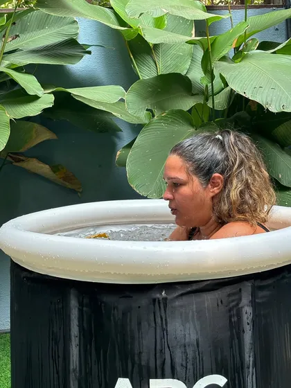 Finding focus in the cold. A member bravely embraces the invigorating challenge of a cold plunge, a key part of our recovery and wellness offerings.