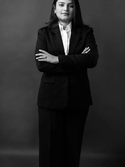 A black and white power pose. This standing shot with crossed arms conveys confidence and authority, making it an excellent choice for a leadership role or a strong personal brand statement.