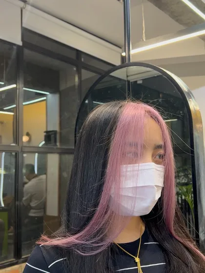 A closer look at the pastel pink face-framing highlights. This technique is designed to brighten your face and add a pop of color right where it counts.