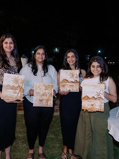 A group of friends proudly displaying the coffee paintings they created at a private party. Shared experiences like this create the best memories.