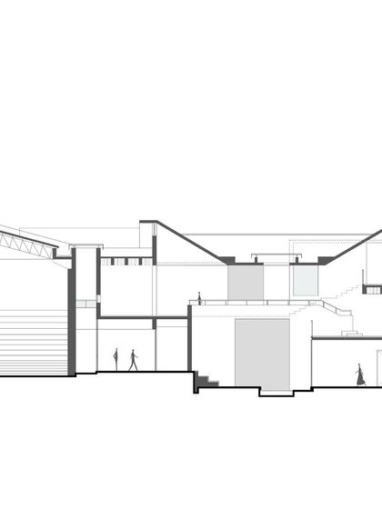 A detailed architectural section of a proposed institute in Goa. This drawing shows the complex relationship between different levels, including a sloped auditorium and various classroom spaces, all designed to integrate with the natural topography of the site.