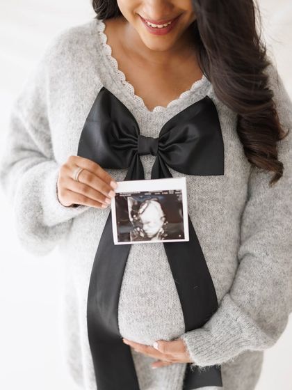 A close-up on the joy of motherhood, with the ultrasound picture held proudly against the baby bump.