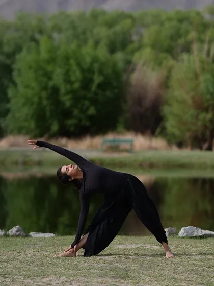 Practicing a variation of Trikonasana (Triangle Pose) in the crisp mountain air of Ladakh. The natural surroundings provide the perfect backdrop for a grounding and expansive yoga practice.