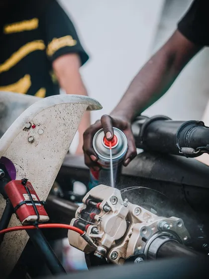 A mechanic applies lubricant to the brake system, part of the meticulous preparation process.