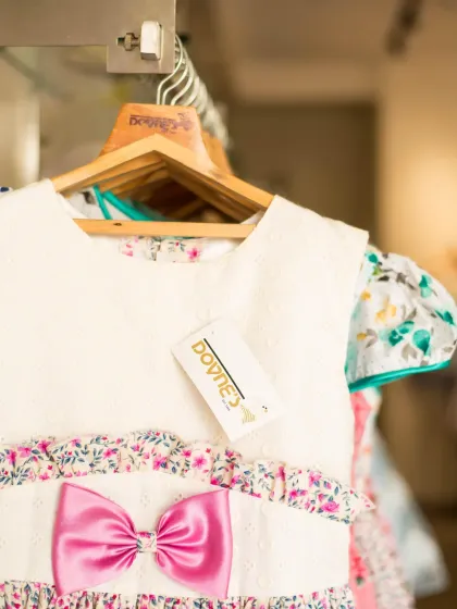 A close-up of a dress hanging in my studio, showing the Doyne's brand tag. Each dress is a piece of my heart, crafted with care and a love for beautiful design.