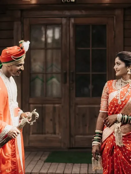 A royal-themed pre-wedding portrait with the groom holding a sword, set against a rustic wooden cabin.