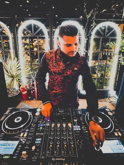 A moodier shot from a wedding performance. The lighting and my focus on the mixer highlight the technical side of my craft, ensuring every transition and track selection is perfect for the moment.