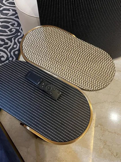 Detail is everything. These nesting side tables feature contrasting textures and patterns, adding a layer of sophistication to the living room. The combination of ribbed black wood and a textured metallic top is an example of our focus on unique material combinations.