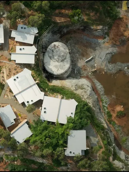 An aerial view of the resort during construction, showing the geometric forms of the buildings taking shape on the raw terrain.