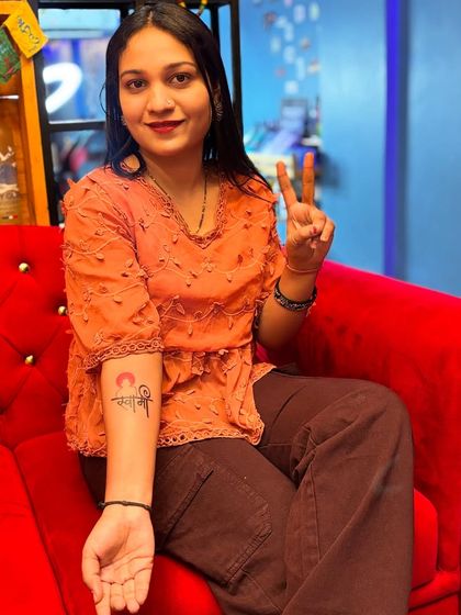 A happy client showing off her new "Swami" tattoo in our studio's lounge area.