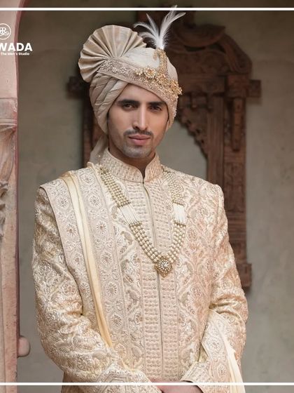 A close-up portrait highlighting the intricate details of the safa and the sherwani's collar. Every element is crafted to perfection for the groom who wants to reign in style.