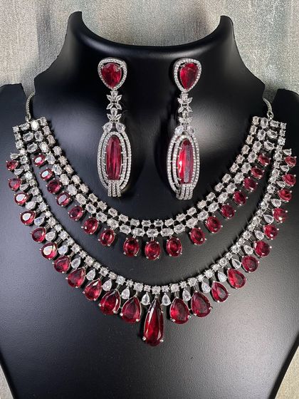 A clear photo of the double-layered ruby and diamond necklace set. Notice the beautiful teardrop shape of the red stones, which adds a classic, regal touch to this rental jewellery piece.