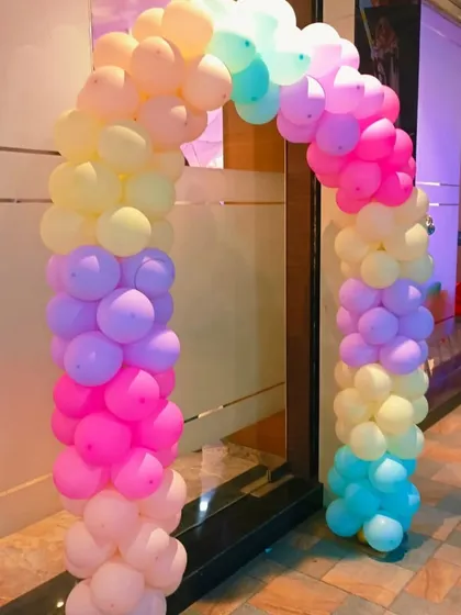 A bright and cheerful balloon arch in a rainbow of pastel colors. This decoration is perfect for adding a pop of color to the entrance of a birthday party or baby shower venue.