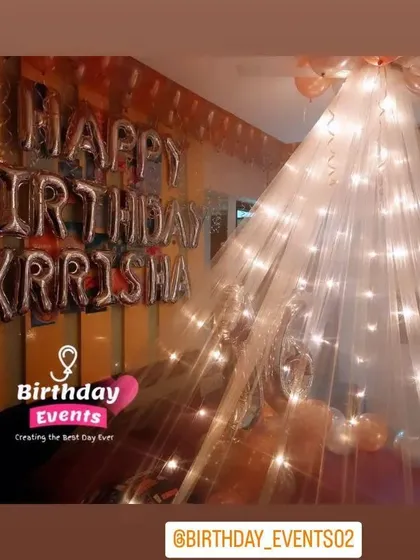 A soft and dreamy birthday room decoration. We used a flowing canopy with fairy lights to create a magical effect, with "Happy Birthday Krrisha" in silver foil letters on the wall.