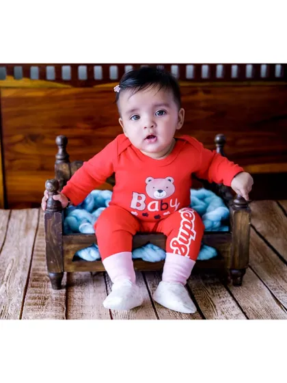 And here is her twin sister, Navya, in a bright red outfit. Capturing individual portraits during a twin session is just as important as photographing them together to show their unique personalities.