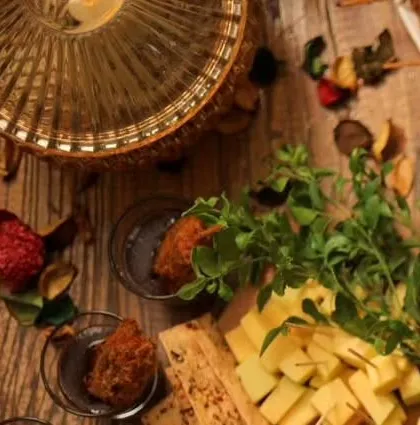 An artistic shot of a catering spread, featuring shot glasses with appetizers and a cheese board.