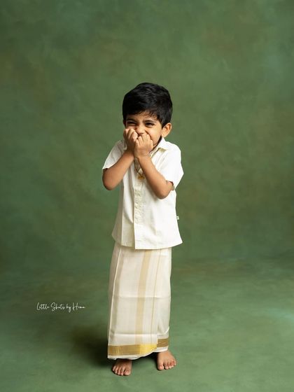 A shy giggle from this little boy in his traditional veshti. Capturing these candid, natural expressions is what makes a photoshoot memorable.