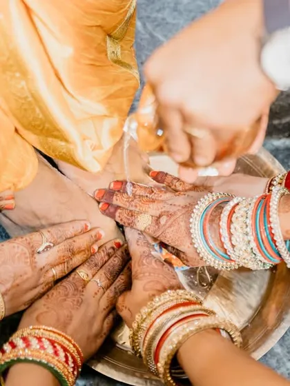 A detail shot of a pre-wedding ritual involving the hands of the women in the family, rich in tradition and symbolism.
