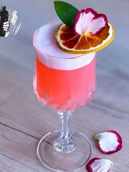 Every glass is a tribute to the artistry of flavors. This pink sour cocktail with a floral and dehydrated fruit garnish is a perfect example of our craft.