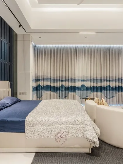 This shot focuses on the bed and the dramatic blue accent wall, with the elegant curtains creating a soft, flowing backdrop. It’s a perfect example of a modern, stylish sanctuary.