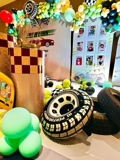 Detailed props like inflatable tires, a school bus cutout, and a photo display board add layers of fun to the car theme.