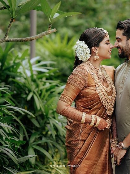 A beautiful portrait of the couple amidst lush greenery, their traditional attire standing out against the natural backdrop.