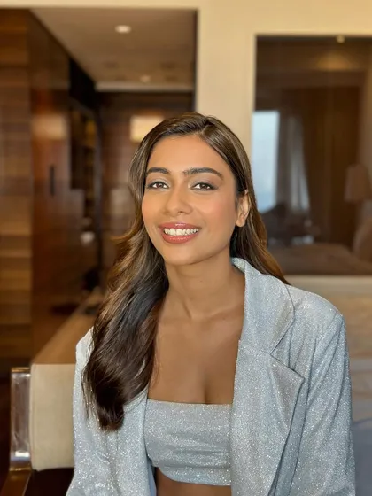 A happy client in her hotel room, ready for her event with flawless makeup and beautifully styled waves.