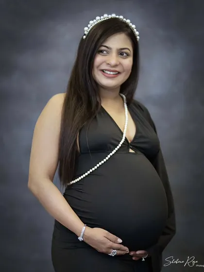 Adding a simple accessory like this pearl headband can bring a touch of classic elegance to your maternity portraits. This momma-to-be looks so happy and chic in her black dress.