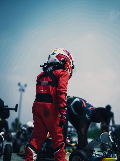 A young driver walking through the pit lane.