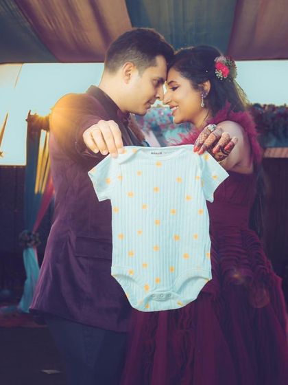 Another creative announcement idea, using a baby onesie. Our gowns provide the perfect elegant backdrop for these memorable photos.