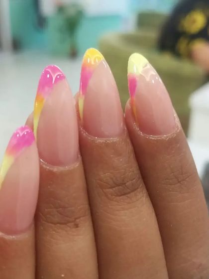 A fun and colorful French tip design with a blend of pink and yellow on the tips.