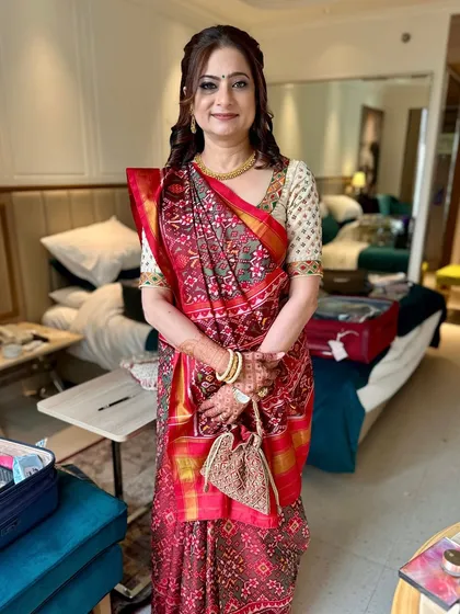A full look showing the elegant makeup and traditional Patola saree. She looks graceful and ready for the wedding festivities.