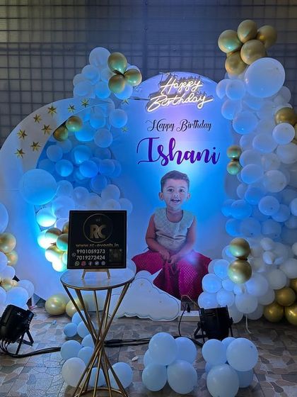 A dreamy 'Twinkle Twinkle Little Star' theme with a moon-shaped backdrop. The setup includes a personalized photo of the birthday girl and a blue, white, and gold balloon arrangement.