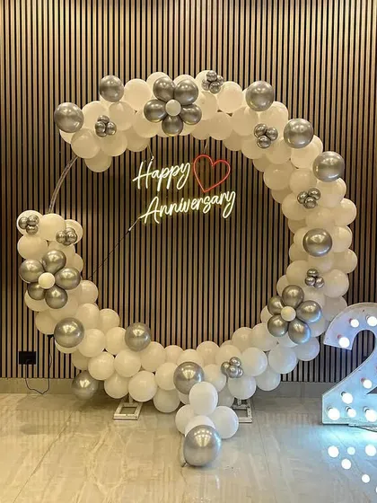 Celebrating a silver jubilee is a momentous occasion. For this 25th wedding anniversary, I designed a clean and sophisticated circular balloon arch in white and silver, paired with a "Happy Anniversary" neon sign and large, illuminated "25" numbers for a perfect photo opportunity.