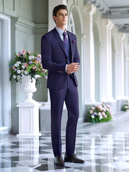 A deep blue three-piece suit styled for a Louis Philippe shoot. The composition in a classic colonnade highlights the suit's structure and rich color, presenting a powerful and polished look for formal business or evening wear.